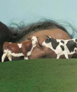 Des figurines de vache devant un homme qui dort (La Vache et son Prisonnier)